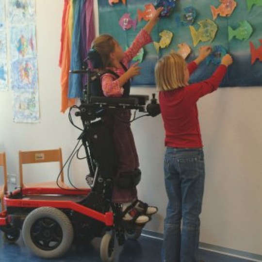 Child sitting in LEVO Combi Jr Standing Power Chair in Class